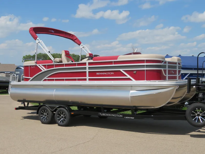 Slide: The Image of 2024 Bennington 22SSR pontoon boat with red and beige design on trailer. - 2