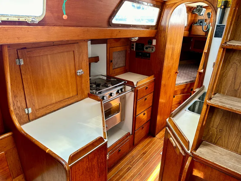 Slide: The Image of 1980 Alden 44 yacht interior with wooden cabinetry and compact kitchen. - 10