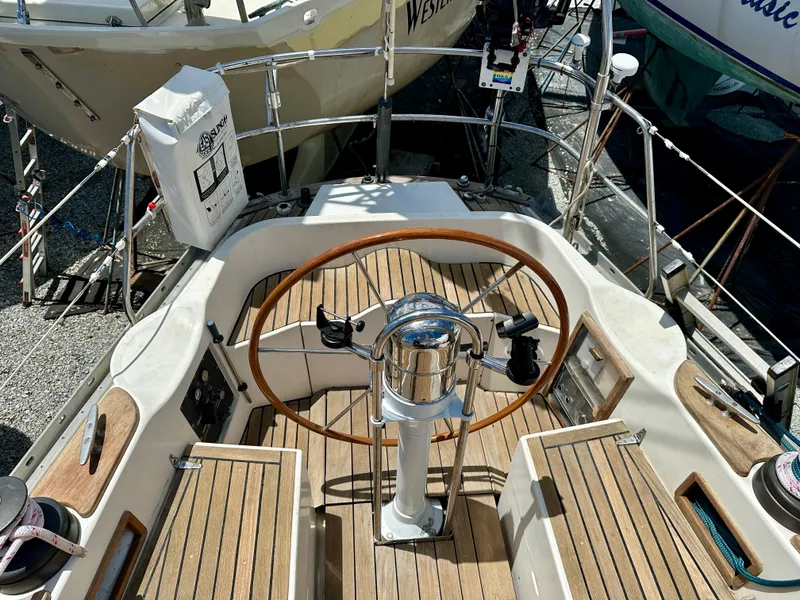 Slide: The Image of 1980 Alden 44 sailboat cockpit with wooden steering wheel and deck. - 11