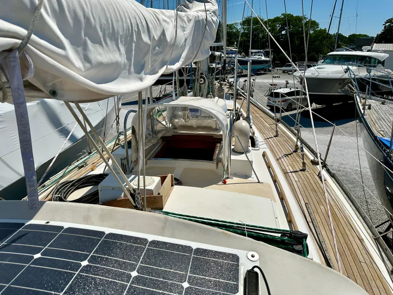 Slide: The Image of 1980 Alden 44 sailboat docked, featuring solar panels and covered cockpit. - 15