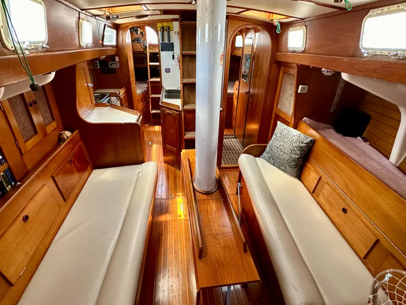 Slide: The Image of Interior of a 1980 Alden 44 sailboat with wooden furnishings and white seating. - 20
