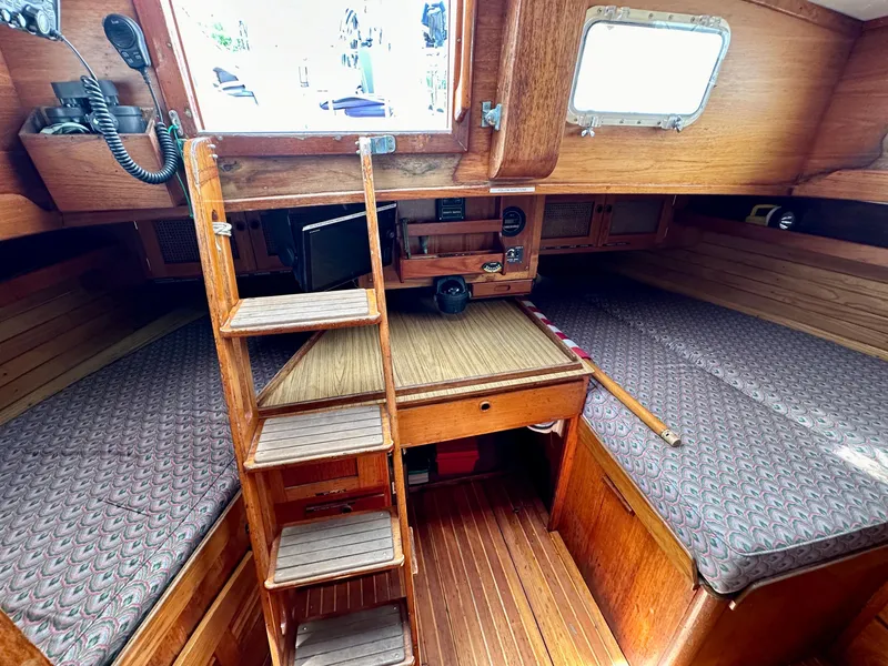 Slide: The Image of Interior of 1980 Alden 44 sailboat with wooden ladder and cozy sleeping area. - 26
