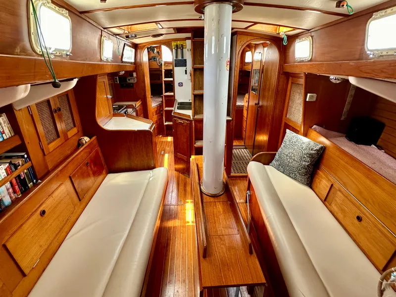 Slide: The Image of Interior of 1980 Alden 44 sailboat with wooden furnishings and white seating. - 27