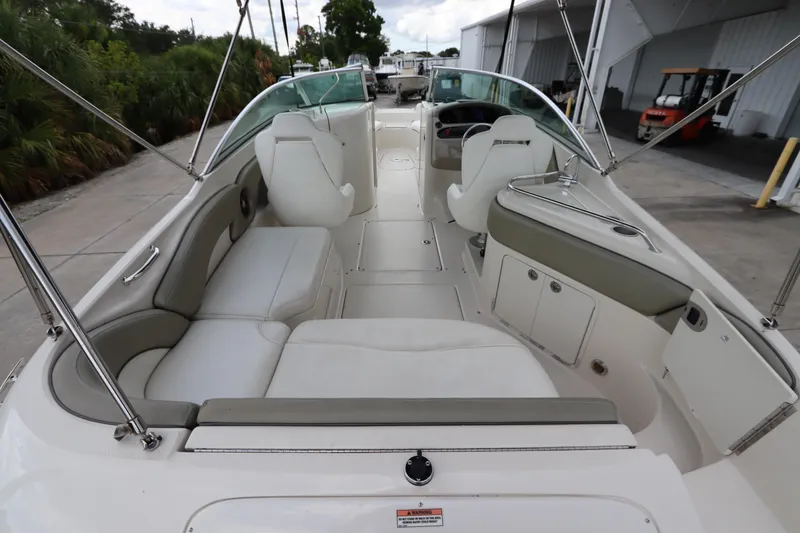 Slide: The Image of 2007 Sea Ray 240 Sundeck boat interior with white seating and spacious layout. - 16