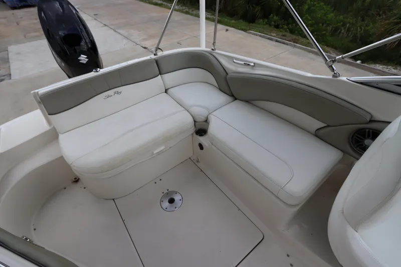 Slide: The Image of 2007 Sea Ray 240 Sundeck interior seating area with white and gray upholstery. - 19