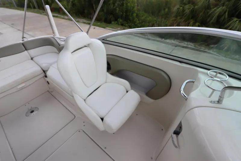 Slide: The Image of 2007 Sea Ray 240 Sundeck interior with white captain's chair and spacious seating. - 21