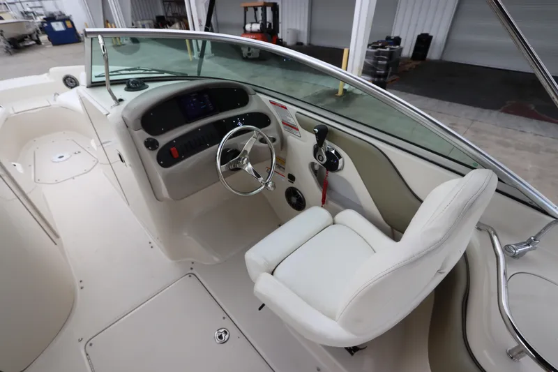 Slide: The Image of 2007 Sea Ray 240 Sundeck boat cockpit with steering wheel and captain's chair. - 22