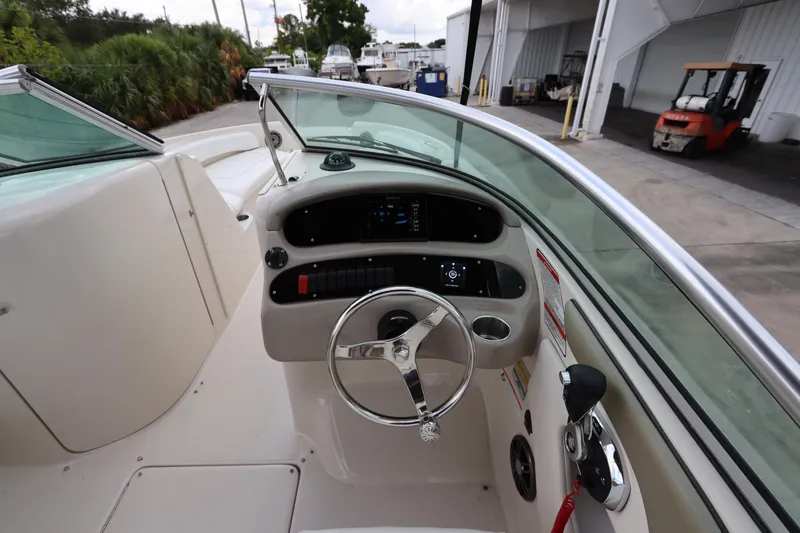 Slide: The Image of 2007 Sea Ray 240 Sundeck boat cockpit with steering wheel and control panel. - 23