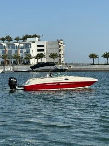 Slide: The Image of 2007 Sea Ray 240 Sundeck boat cruising near modern waterfront homes. - 3