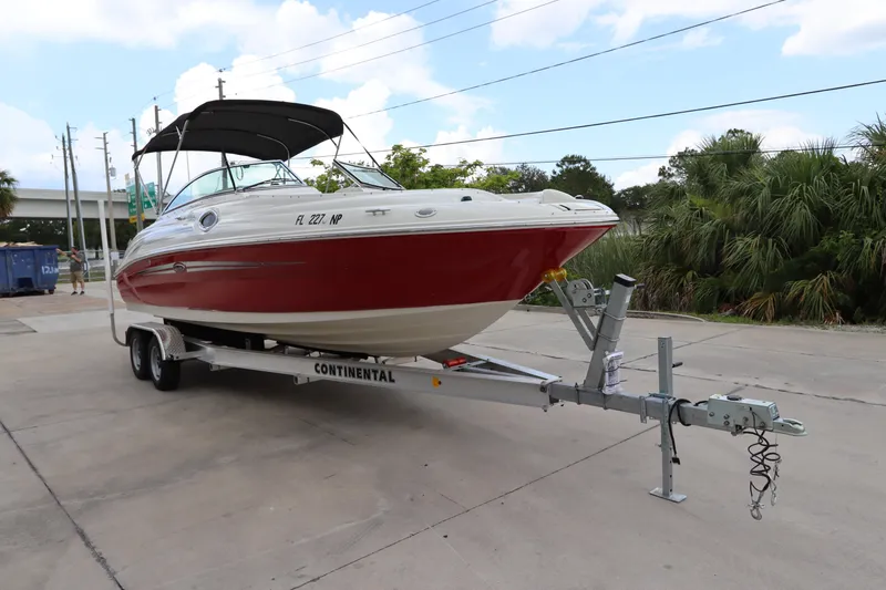 Slide: The Image of 2007 Sea Ray 240 Sundeck boat on a Continental trailer in a parking lot. - 8