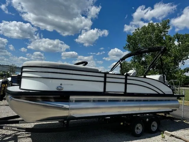 Slide: The Image of 2024 Harris Cruiser 230 pontoon boat on a trailer under a blue sky. - 1