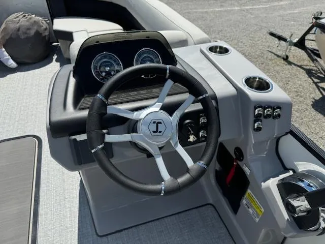 Slide: The Image of 2024 Harris Cruiser 230 boat steering console with gauges and cup holders. - 5