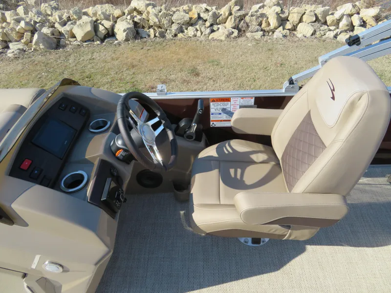 Slide: The Image of 2024 Bennington 22SXSB boat helm with beige captain's chair and control panel. - 11