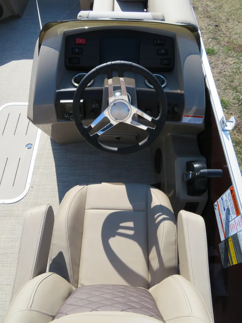 Slide: The Image of 2024 Bennington 22SXSB boat helm with steering wheel and captain's chair. - 8