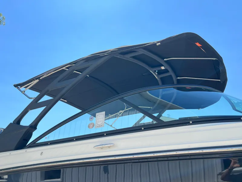 Slide: The Image of 2025 Sea Ray SDX 270 boat with black canopy and sleek design. - 3