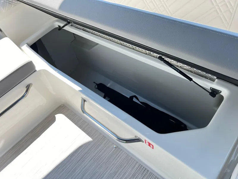 Slide: The Image of 2025 Sea Ray SDX 270 boat storage compartment with open lid. - 8