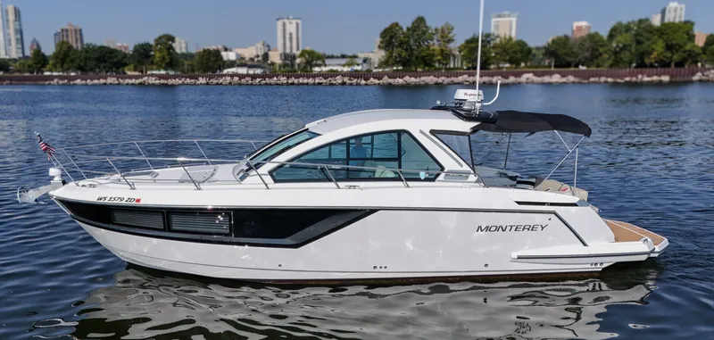 The Image of 2017 Monterey 360 Sport Coupe boat on calm water with city skyline background. - 0