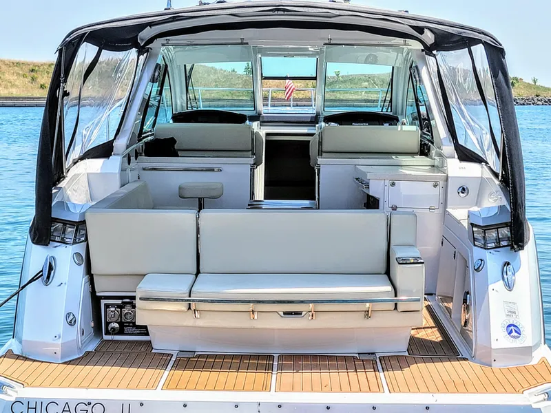 Slide: The Image of 2017 Monterey 360 Sport Coupe boat interior with seating, docked on calm water. - 13