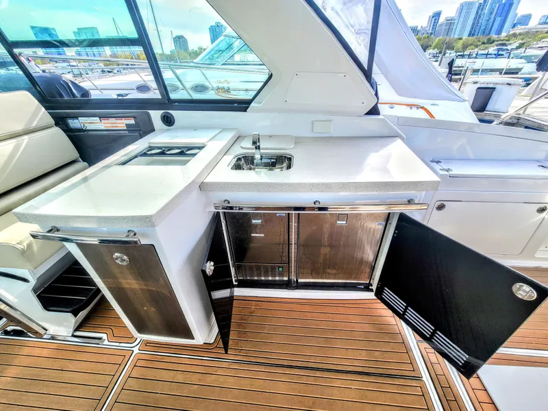 Slide: The Image of 2017 Monterey 360 Sport Coupe yacht interior with kitchenette and city skyline view. - 14