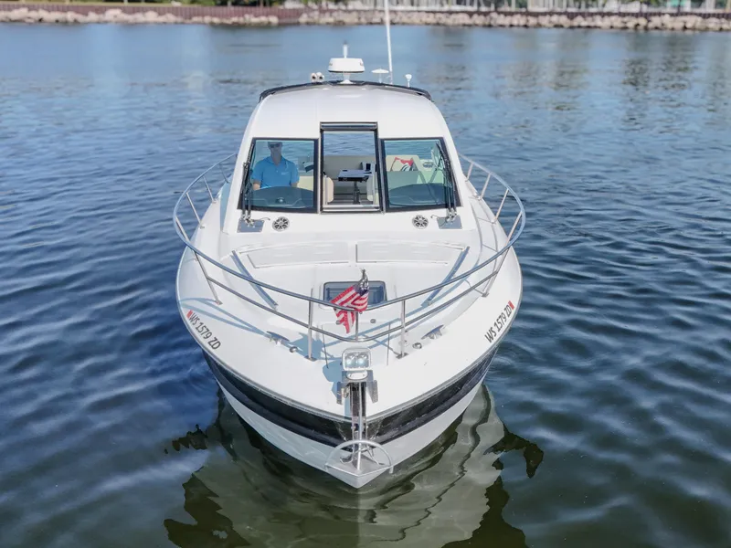 Slide: The Image of 2017 Monterey 360 Sport Coupe on calm water, front view with American flag. - 3