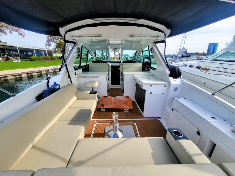 Slide: The Image of 2017 Monterey 360 Sport Coupe interior with seating, table, and marina view. - 7