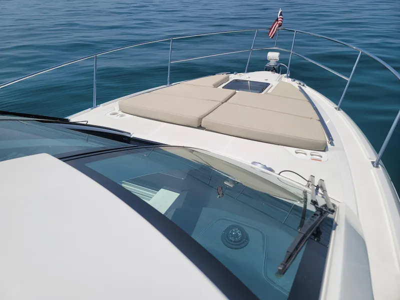 Slide: The Image of 2017 Monterey 360 Sport Coupe boat on calm water, featuring spacious deck and American flag. - 8