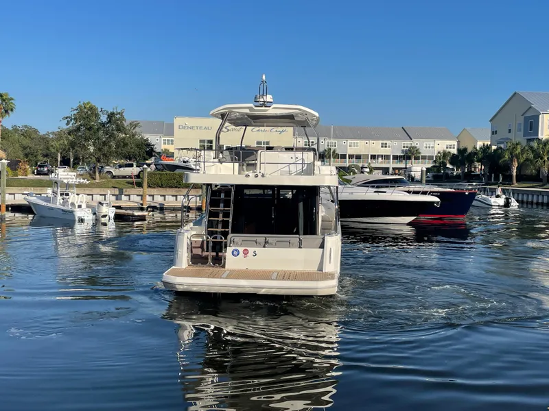 Slide: The Image of 2025 Beneteau Swift Trawler 48 docked in a marina. - 10