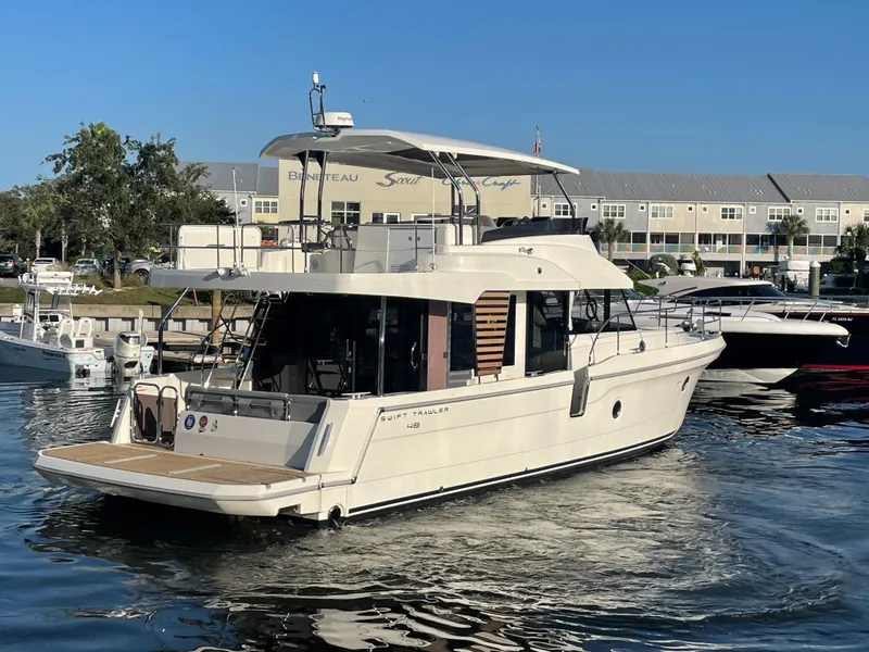 Slide: The Image of 2025 Beneteau Swift Trawler 48 docked at marina, rear view. - 12