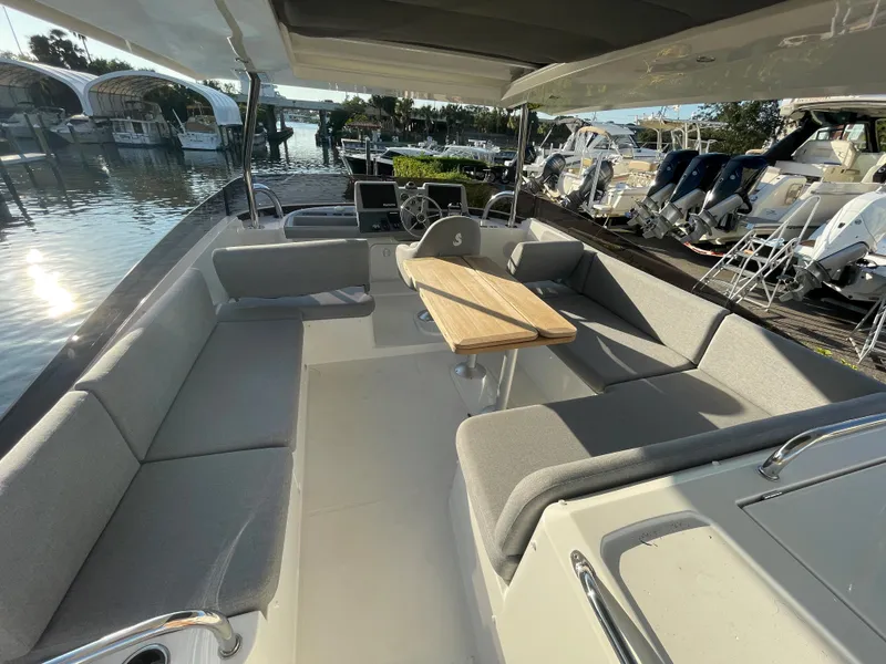 Slide: The Image of 2025 Beneteau Swift Trawler 48 interior with spacious seating and wooden table. - 17