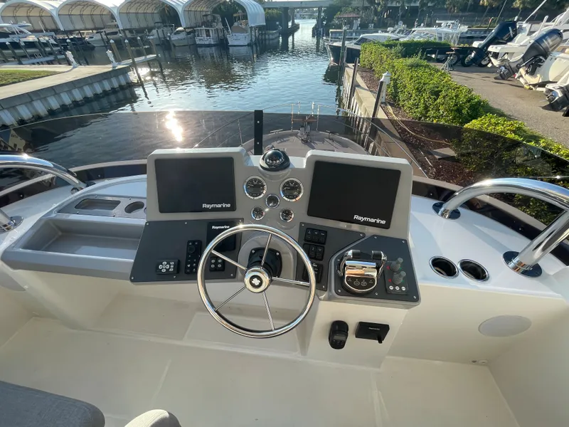 Slide: The Image of 2025 Beneteau Swift Trawler 48 helm station with dual Raymarine displays at marina. - 19