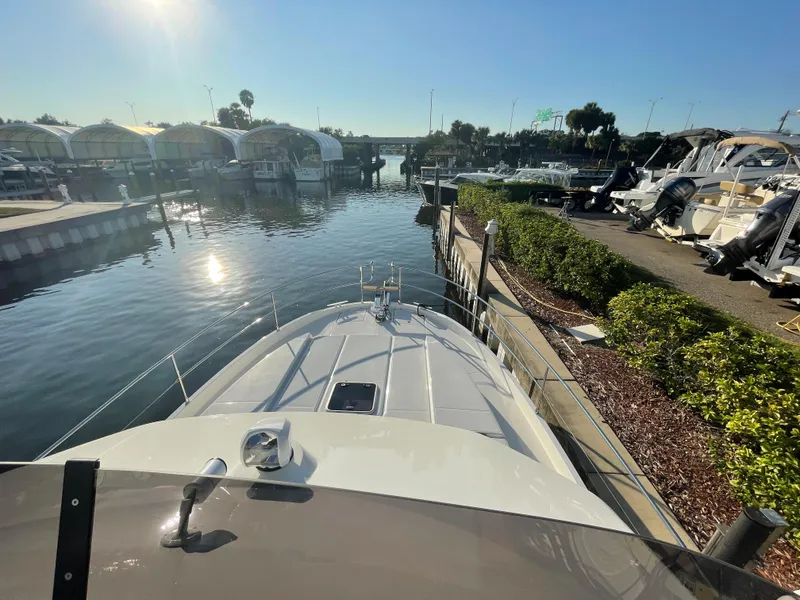 Slide: The Image of 2025 Beneteau Swift Trawler 48 docked at a marina on a sunny day. - 20