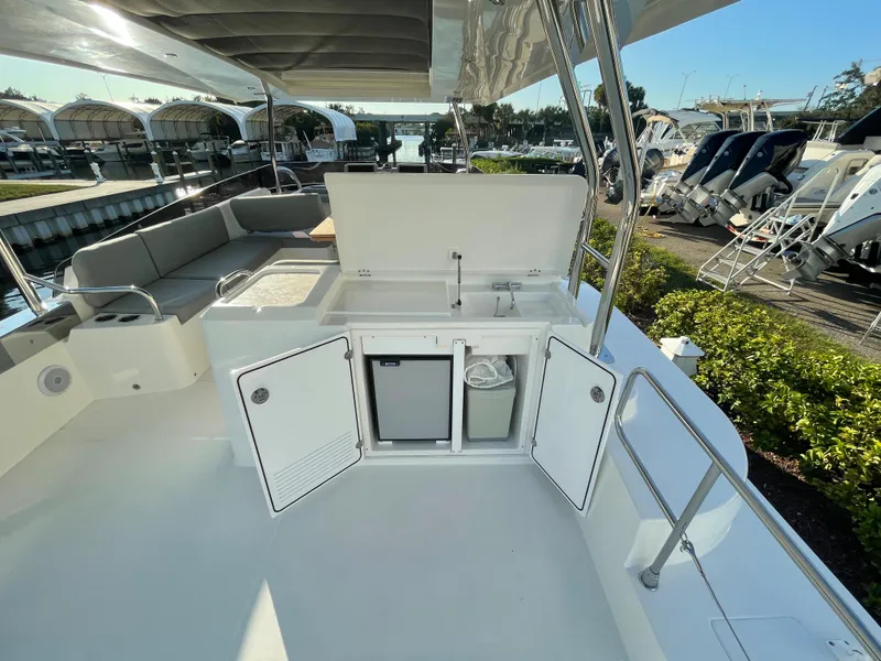 Slide: The Image of Beneteau Swift Trawler 48 (2025) outdoor kitchen and seating area on a sunny day. - 21