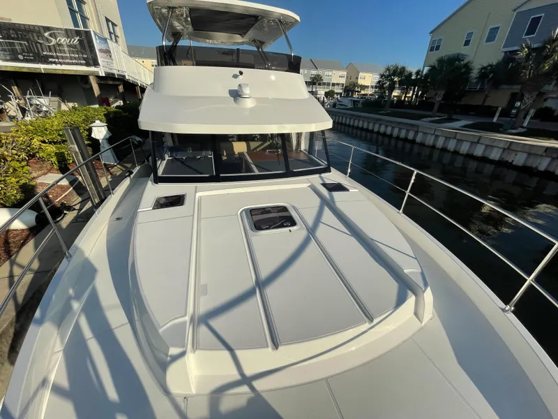 Slide: The Image of 2025 Beneteau Swift Trawler 48 docked, showcasing spacious deck and sleek design. - 26