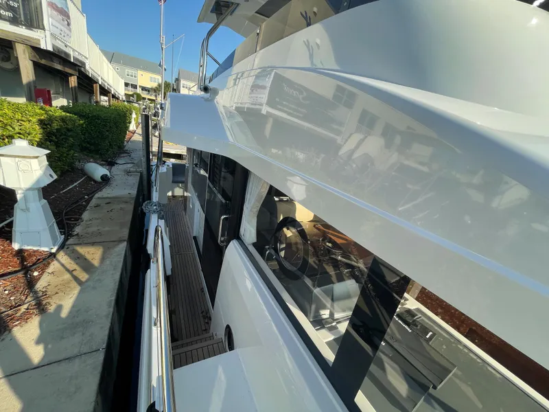 Slide: The Image of 2025 Beneteau Swift Trawler 48 docked, side view showcasing sleek design and modern features. - 28