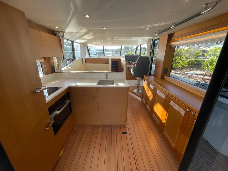 Slide: The Image of Interior of 2025 Beneteau Swift Trawler 48 with modern kitchen and helm station. - 33