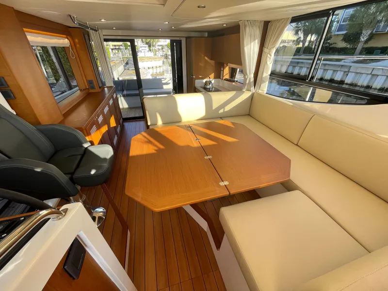 Slide: The Image of Interior of 2025 Beneteau Swift Trawler 48 with wooden table and beige seating. - 37