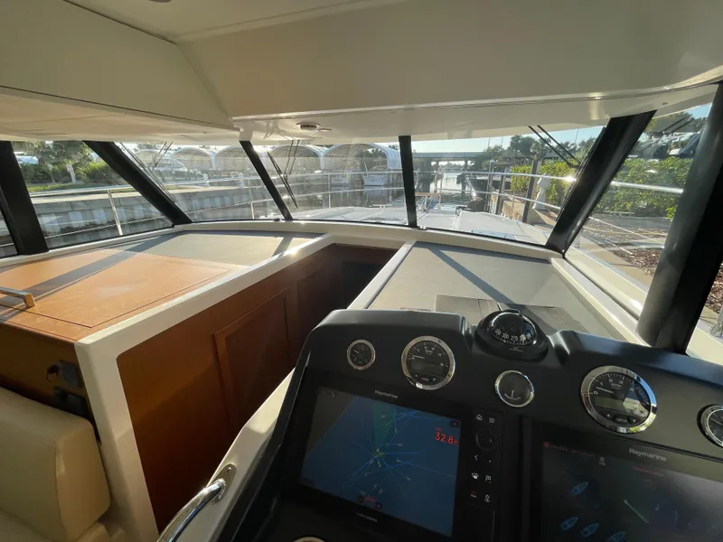 Slide: The Image of Interior helm of 2025 Beneteau Swift Trawler 48 with navigation screens and panoramic windows. - 39