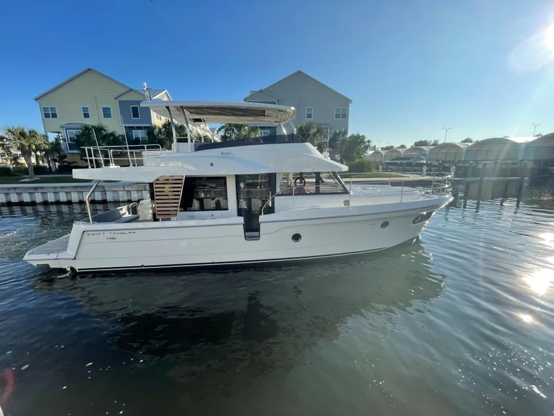 Slide: The Image of 2025 Beneteau Swift Trawler 48 cruising in a calm marina. - 4