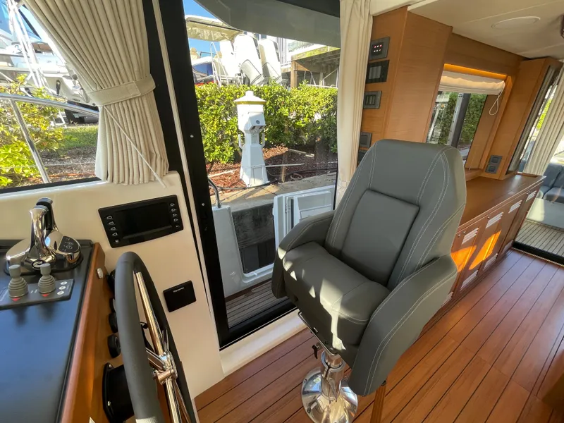 Slide: The Image of Interior helm station of 2025 Beneteau Swift Trawler 48 with captain's chair and control panel. - 40