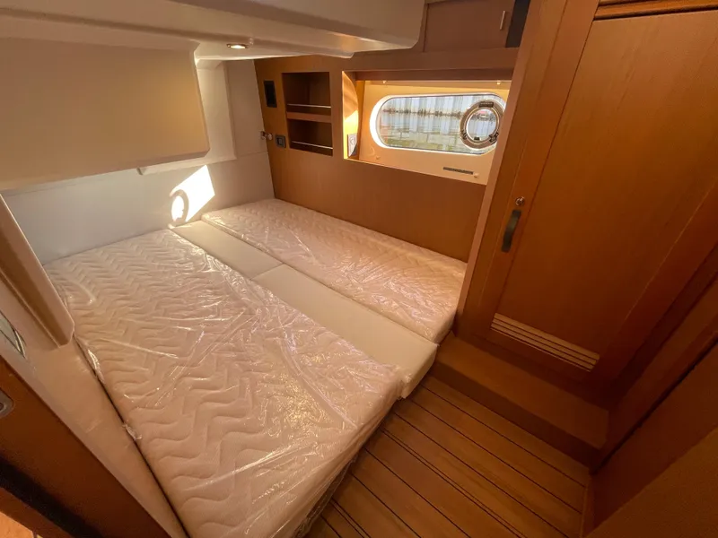 Slide: The Image of 2025 Beneteau Swift Trawler 48 cabin with twin beds and wooden interior. - 41