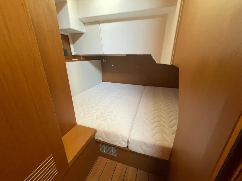 Slide: The Image of 2025 Beneteau Swift Trawler 48 cabin with double bed and wooden interior. - 42