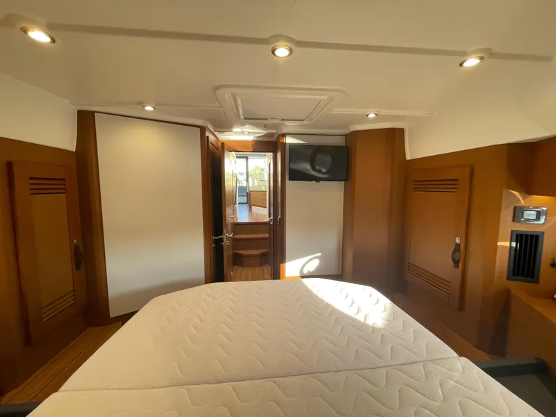 Slide: The Image of Interior cabin of 2025 Beneteau Swift Trawler 48 with bed and wooden finishes. - 48