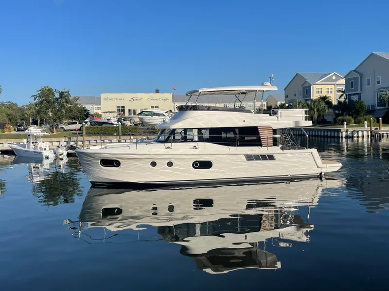 Slide: The Image of 2025 Beneteau Swift Trawler 48 docked in a marina on a clear day. - 6