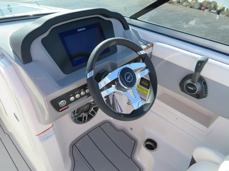 Slide: The Image of 2024 Chaparral 23 Surf boat dashboard with steering wheel and control panel. - 12