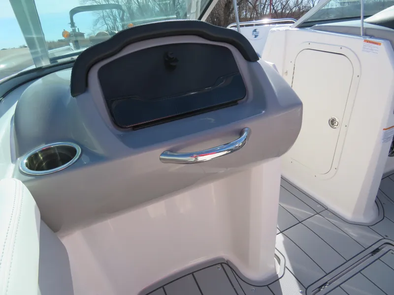 Slide: The Image of 2024 Chaparral 23 Surf boat interior dashboard with storage compartment and cup holder. - 16