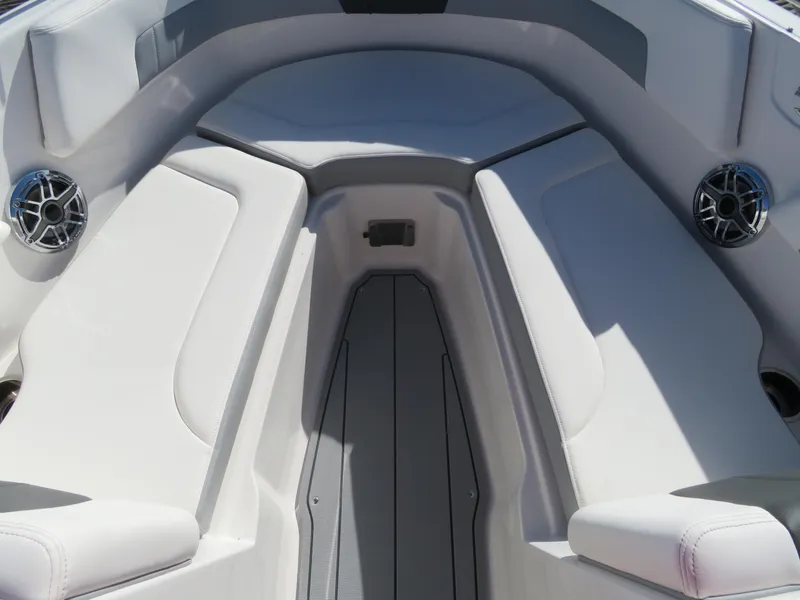 Slide: The Image of 2024 Chaparral 23 Surf boat interior with cushioned seating and built-in speakers. - 18