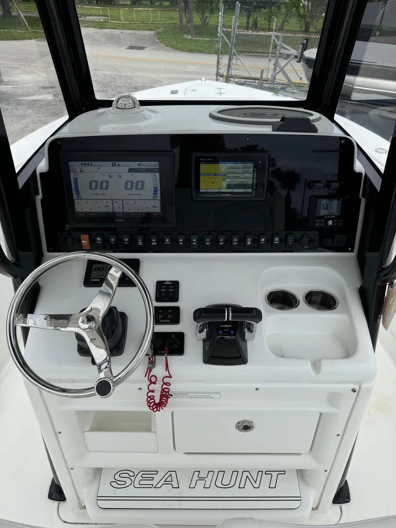 Slide: The Image of 2019 Sea Hunt Gamefish 27 Forward Seating boat console with steering wheel and navigation screens. - 21