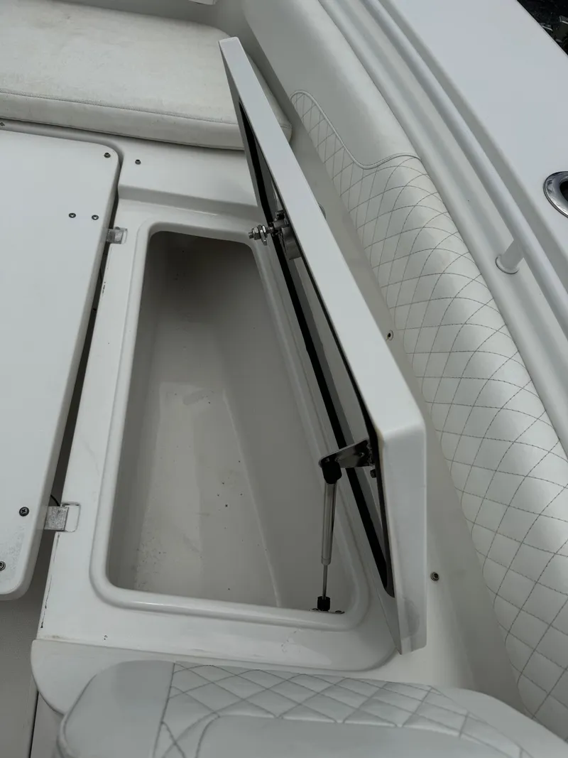 Slide: The Image of 2019 Sea Hunt Gamefish 27 Forward Seating storage compartment with open hatch. - 24