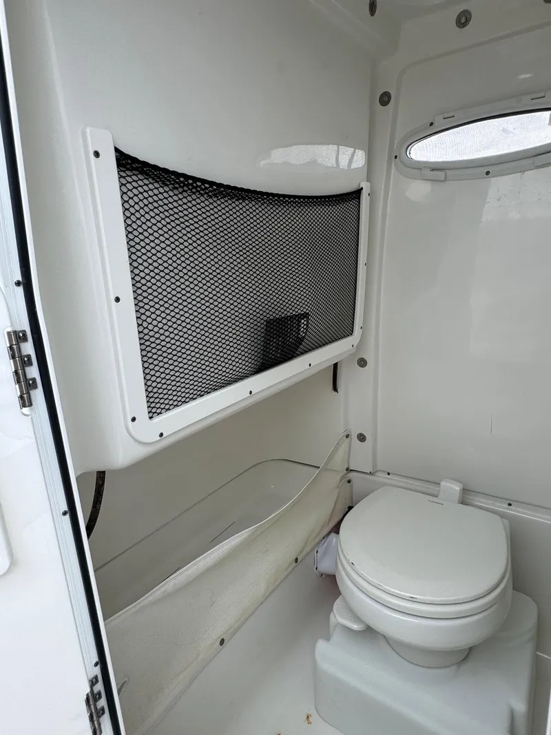 Slide: The Image of 2019 Sea Hunt Gamefish 27 Forward Seating boat interior with toilet and storage. - 42
