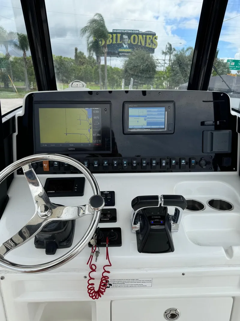 Slide: The Image of 2019 Sea Hunt Gamefish 27 Forward Seating helm with navigation screens and controls. - 9